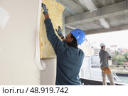 craftsman insulating a wall. Стоковое фото, агентство Ingram Publishing / Фотобанк Лори