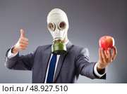 Businessman with gas mask and apple. Стоковое фото, агентство Ingram Publishing / Фотобанк Лори