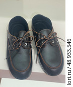 Brown leather lace-up shoes on white shelf. Редакционное фото, фотограф Данил Руденко / Фотобанк Лори