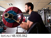 biceps preacher bench arm curl workout man at fitness gym. Стоковое фото, агентство Ingram Publishing / Фотобанк Лори