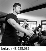 Aerobics elliptical walker trainer group at fitness gym workout. Стоковое фото, агентство Ingram Publishing / Фотобанк Лори