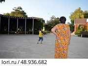 A grandmother and her grandson go for a walk playing sports on a summer day. Стоковое фото, фотограф K. / Фотобанк Лори
