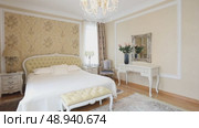 Explore a beautifully designed bedroom with a large, elegant bed. Стоковое видео, видеограф Cantemir Dumitru / Фотобанк Лори