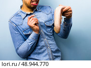 Squeamish young man holding a raw ox tongue. Стоковое фото, агентство Ingram Publishing / Фотобанк Лори