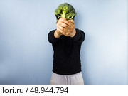 Young man holding broccoli . Стоковое фото, агентство Ingram Publishing / Фотобанк Лори