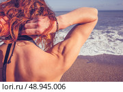 Young woman touching her hair on the beach. Стоковое фото, агентство Ingram Publishing / Фотобанк Лори