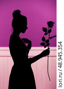Female silhouette holding the flower. Стоковое фото, агентство Ingram Publishing / Фотобанк Лори