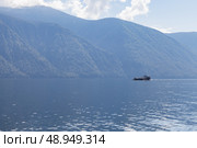 Small ferry with passenger and cars placed on deck sails the Teletskoye lake. Стоковое фото, фотограф EugeneSergeev / Фотобанк Лори