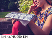 Woman sitting in a garden with an icepack on her wrist. Стоковое фото, агентство Ingram Publishing / Фотобанк Лори