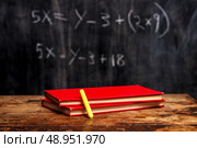 Books and chalk with math problem in background . Стоковое фото, агентство Ingram Publishing / Фотобанк Лори