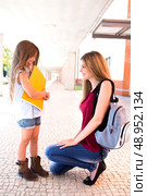 Mother saying goodbye to her daughter at shool. Стоковое фото, агентство Ingram Publishing / Фотобанк Лори