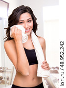 Fitness woman wiping sweat with a towel. Стоковое фото, агентство Ingram Publishing / Фотобанк Лори
