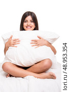 Little cute girl grabbing pillow over white. Стоковое фото, агентство Ingram Publishing / Фотобанк Лори