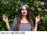 trendy teenager model with kerchief posing on flowers BG. Стоковое фото, агентство Ingram Publishing / Фотобанк Лори