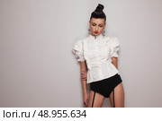 Vintage style leggy model posing in white shirt and black high shorts. Стоковое фото, агентство Ingram Publishing / Фотобанк Лори