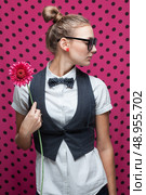 Portrait of trendy girl with ponytail hairstyle and pink flower. Стоковое фото, агентство Ingram Publishing / Фотобанк Лори
