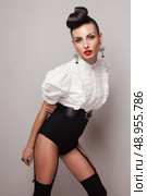 Pin up styling model posing in stocking, high shorts and white shirt. Updo. Стоковое фото, агентство Ingram Publishing / Фотобанк Лори