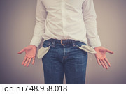 Young broke man is showing his empty pockets. Стоковое фото, агентство Ingram Publishing / Фотобанк Лори