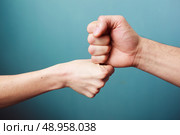 Young man and woman are fist bumping. Стоковое фото, агентство Ingram Publishing / Фотобанк Лори