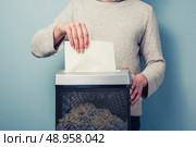 Man is shredding a piece of paper. Стоковое фото, агентство Ingram Publishing / Фотобанк Лори