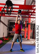 kettlebell swinging man weightlifting workout exercise at gym. Стоковое фото, агентство Ingram Publishing / Фотобанк Лори