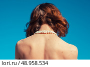 A young woman is tanning her back on a sunny day with a clear blue sky. Стоковое фото, агентство Ingram Publishing / Фотобанк Лори