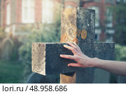 A woman’s hand is touching a gravestone at sunset. Стоковое фото, агентство Ingram Publishing / Фотобанк Лори