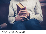 Nervous young man is clutching a book and spilling coffee on the sofa. Стоковое фото, агентство Ingram Publishing / Фотобанк Лори