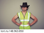 A cheeky cowboy builder is wearing a high visibility vest. Стоковое фото, агентство Ingram Publishing / Фотобанк Лори