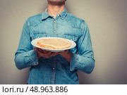 Young man is presenting a plate with a stack of pancakes. Стоковое фото, агентство Ingram Publishing / Фотобанк Лори