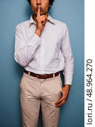 Young man with his finger on his lips. Стоковое фото, агентство Ingram Publishing / Фотобанк Лори