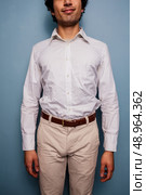 Happy young man against blue background. Стоковое фото, агентство Ingram Publishing / Фотобанк Лори