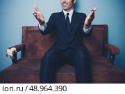 Happy young businessman sitting on a sofa. Стоковое фото, агентство Ingram Publishing / Фотобанк Лори
