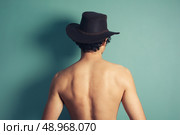 Rear view of a young shirtless man wearing acowboy hat. Стоковое фото, агентство Ingram Publishing / Фотобанк Лори