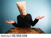 Young man with bag over head doesn’t know. Стоковое фото, агентство Ingram Publishing / Фотобанк Лори