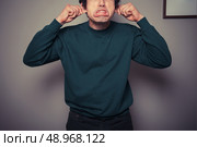 A young man is gesturing and pulling silly faces. Стоковое фото, агентство Ingram Publishing / Фотобанк Лори
