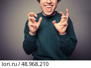 A young man is gesturing and pulling silly faces. Стоковое фото, агентство Ingram Publishing / Фотобанк Лори