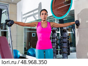 dumbbell lateral shoulder flies fly girl workout exercise at gym. Стоковое фото, агентство Ingram Publishing / Фотобанк Лори