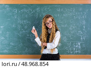 Clever nerd pupil blond girl in green board thinking student schoolgirl. Стоковое фото, агентство Ingram Publishing / Фотобанк Лори