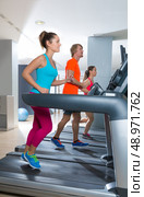 Gym treadmill group running indoor women and blond man. Стоковое фото, агентство Ingram Publishing / Фотобанк Лори