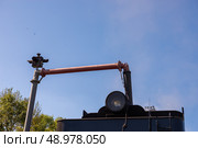 Осташков Тверская область Россия-25.08.2024. РЕТРОПОЕЗД «СЕЛИГЕР» БОЛОГОЕ – ОСТАШКОВ на паровой тяге. Тендер паровоза заправляют водой из гидроколонки через "хобот" и заправочный люк на железнодорожной станции Осташков. Ostashkov Tver region, Russia-08/25/2024. RETROPOEZD "SELIGER" BOLOGOE – OSTASHKOV on steam traction. The locomotive's tender is filled with water from a hydraulic column through a "trunk" and a filling hatch at the Ostashkov railway station. Редакционное фото, фотограф Мария / Фотобанк Лори