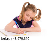 Blond kid indented girl student with spiral notebook in pupil desk. Стоковое фото, агентство Ingram Publishing / Фотобанк Лори
