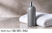Gray bottle on white towel with water droplets in a serene setting. Серая бутылка на белом полотенце с капельками воды в безмятежной обстановке. Стоковое AI-изображение, AI-художник Katsiaryna Repich / Фотобанк Лори