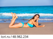 Brunette tourist lying in beach sand tanning happy in summer vacation. Стоковое фото, агентство Ingram Publishing / Фотобанк Лори