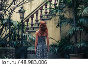 A young woman is admiring an old colonial staircase in a courtyard. Стоковое фото, агентство Ingram Publishing / Фотобанк Лори