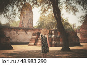 A young woman is exploring the ancient ruins of a buddhist temple city. Стоковое фото, агентство Ingram Publishing / Фотобанк Лори