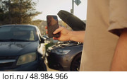 Participant in accident takes photographs of colliding vehicles in order to use them as evidence in court to prove their innocence. Стоковое видео, видеограф Strunov David / Фотобанк Лори