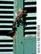 light green wood venetian blind and a rusty chain in la boca buenos aires argentina. Стоковое фото, агентство Ingram Publishing / Фотобанк Лори