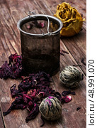 tea strainer and different varieties of tea leaves on wooden background.The toned image. Стоковое фото, агентство Ingram Publishing / Фотобанк Лори