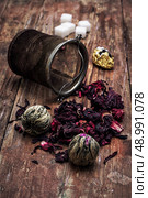 tea strainer and different varieties of tea leaves on wooden background.The toned image. Стоковое фото, агентство Ingram Publishing / Фотобанк Лори